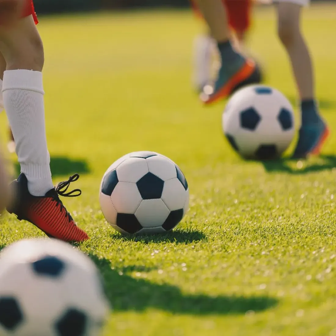 Bambini in esercizio con i palloni durante la scuola calcio