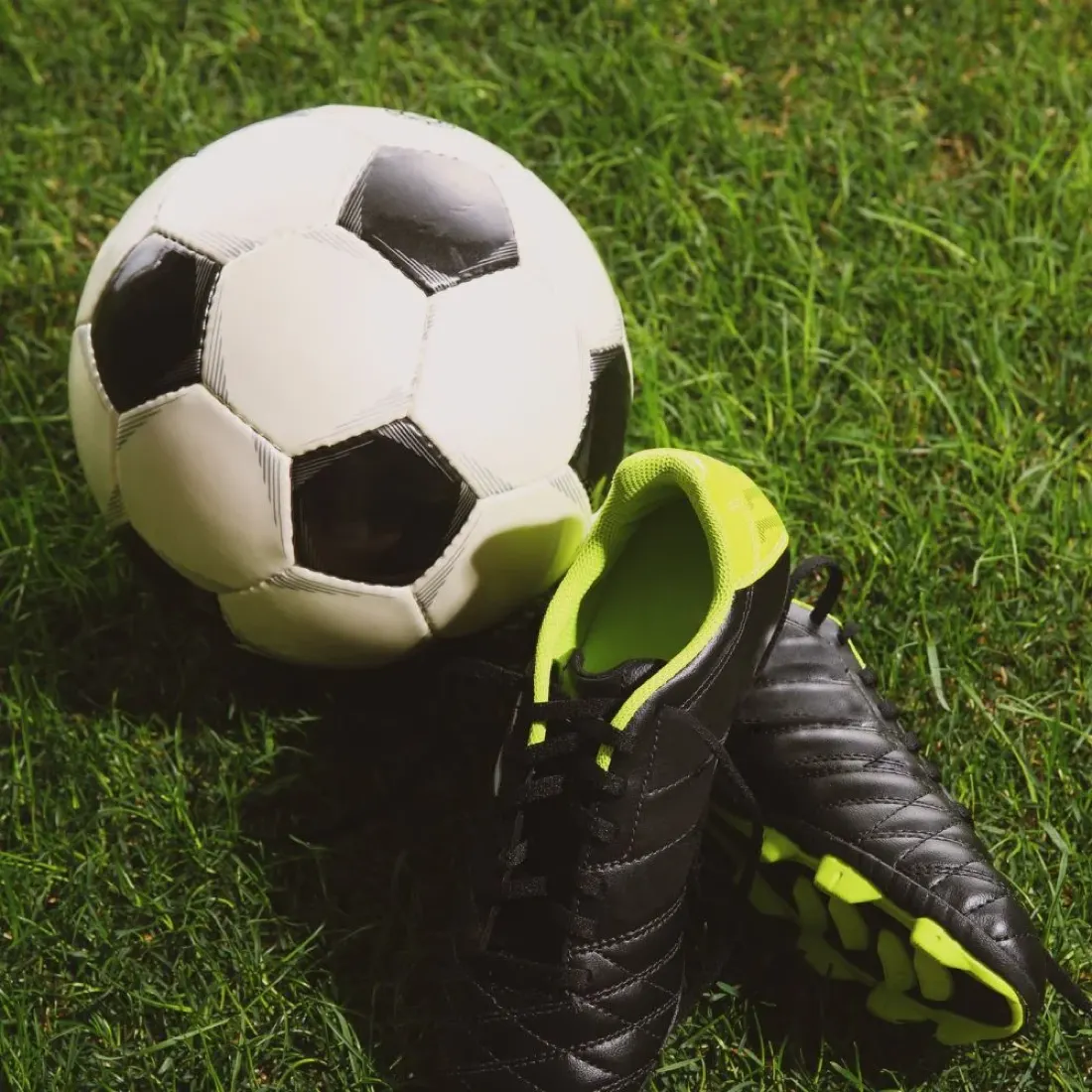 Scarpini da calcio e pallone sul prato